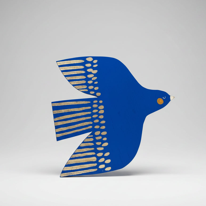 Blue bird-shaped object with gold patterns on a light gray background